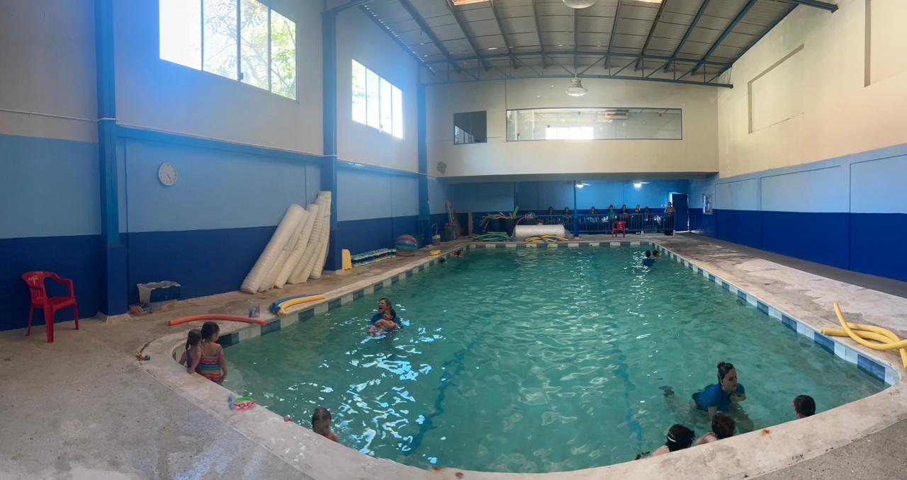 Maestra de Swimsters guiando a niños en clase de natación